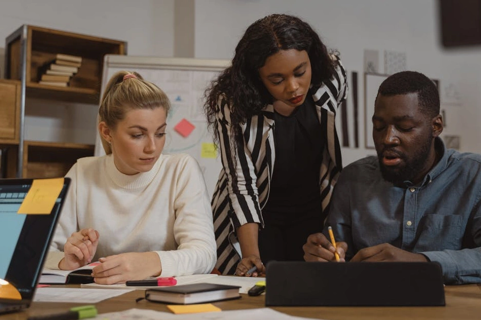 A diverse team of professionals collaborating around a table in a bright, modern office.